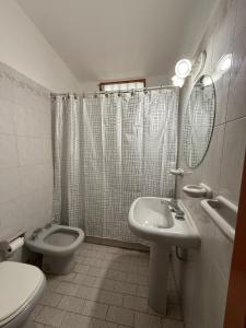 a bathroom with a toilet and a sink at Chalet Pino azul in Villa Carlos Paz +12 photos