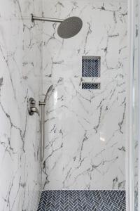 a shower with white marble walls and a window at Charming 3Bedroom Home in Vibrant Church Hill - Walk to Parks and Dining in Richmond +66 photos