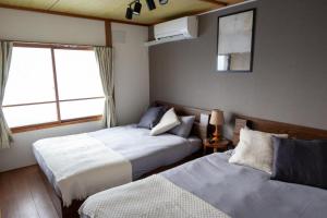 a bedroom with two beds and a window at Biei Relax Stay B in Biei