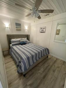 a bedroom with a bed with a ceiling fan at Beach House in Oceanlakes Campgrounds Myrtle Beach, South Carolina in Myrtle Beach +17 photos