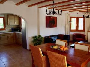 a kitchen and living room with a wooden dining table at Villa in Monte Pego near Stunning Beaches in Adsubia