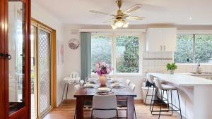 una cocina con una mesa con flores. en Lucerne Escape by GoodLive, en Frankston