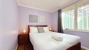Un dormitorio con una cama con sábanas blancas y una ventana. en Lucerne Escape by GoodLive, en Frankston 37 fotos más