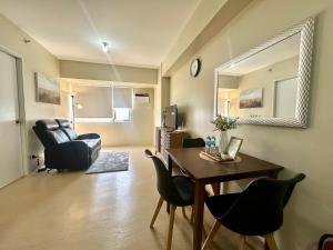a living room with a dining room table and chairs at Pool View Cozy 1-Bedroom Unit Avida Aspira Tower 2 in Cagayan de Oro