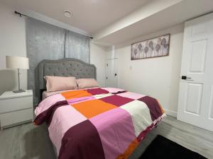エドモントンにあるComfy 2 Bedroom Suite Getawayのベッドルーム1室(カラフルな毛布付きのベッド1台付)