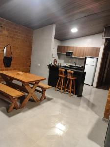 a kitchen with a wooden table and a table and chairs at Sua casa na serra in Bezerros