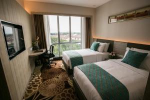 a hotel room with two beds and a window at V8 Hotel Johor Bahru in Johor Bahru