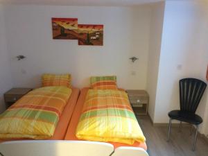 two twin beds in a room with a chair at Chalet in Saas Fee near Ski Slopes in Saas-Grund