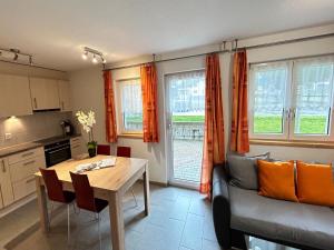 a kitchen and living room with a table and a couch at Älpi Retreat by Saas Grund in Saas-Grund
