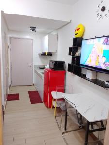 a small kitchen with a red refrigerator and a tv at 1 Bedroom Cozy Condo Unit with Netflix & Free Wifi in Trees Residences in Manila +66 photos