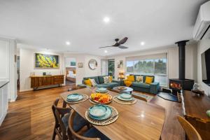 a living room with a table and a fireplace at Wattle Cottage - A Stylish Hinterland Escape in Maleny