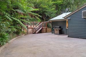 a garage with a staircase leading to a house at Wattle Cottage - A Stylish Hinterland Escape in Maleny +27 photos