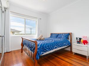 Un dormitorio con una cama y una ventana. en Thorneside seaside dream home near the blue sea, en Birkdale