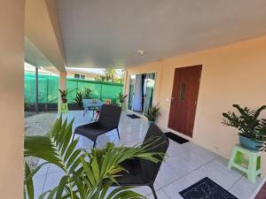 een woonkamer met stoelen en planten. bij Te Anuanua Lodge in Avatoru