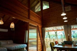a dining room with a table and a room with a window at nasusatoyamafield in Otawara