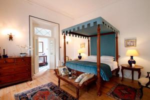 a bedroom with a canopy bed and a wooden floor at Casa de Mogofores in Anadia +57 photos