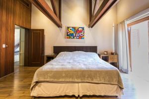 a bedroom with a bed and a painting on the wall at Vila Balinesa in Porto Alegre