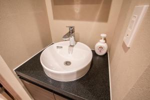 a bathroom with a white sink and a bottle of soap at Uhome Fabric Hotel in Tokyo +38 photos