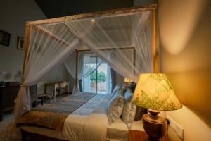 a bedroom with a canopy bed with a window at Serendipity Mirissa in Mirissa