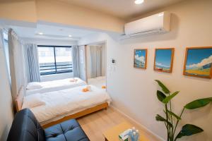 a small bedroom with a bed and a window at Uhome Fabric Hotel in Tokyo