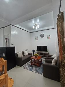a living room with two couches and a tv at The Bocol's House Stay in Sampong +7 photos