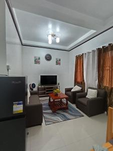 a living room with couches and a coffee table at The Bocol's House Stay in Sampong