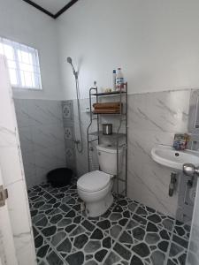 a bathroom with a toilet and a sink at The Bocol's House Stay in Sampong