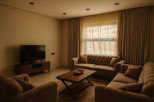 a living room with a couch and a television at شقه غرفتين وصاله بشرفه in Al-ʿUla