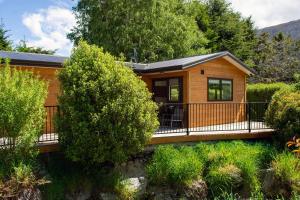 a wooden cabin with a balcony and trees at Kingston TOP 10 Holiday Park in Kingston