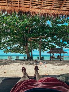 a person laying on the beach with their feet in the sand at Samma Karuna Beach & Wellness Resort - Intoxicants free in Srithanu +70 photos