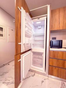 アブダビにあるMaryah Island 1 Bed Junior Next to Cleveland Hospital by Central Stayのキッチンにあるドアが開いたままの空の冷蔵庫