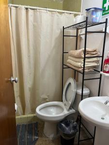 a bathroom with a toilet and a shower curtain at Cómodo departamento en el corazón de Cancún in Cancún