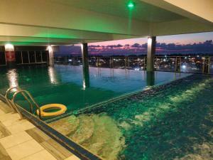 a swimming pool with a view of a city at night at VI Homestay in Miri +7 photos