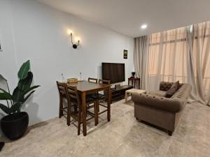 a living room with a dining room table and a couch at VI Homestay in Miri
