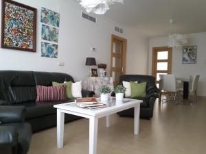 a living room with a black couch and a white table at Apartamento Berenguela in Córdoba