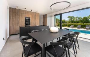 Una cocina y un comedor con una mesa y sillas negras. en Villa Karbula, en Poreč