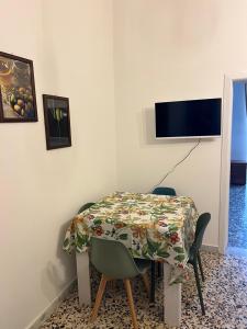 una sala da pranzo con un tavolo e una TV a parete di Domus Olea & Opuntia Salento a Galatone
