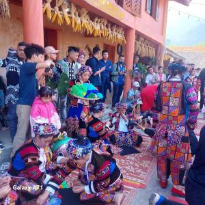 Un grupo de personas vestidas con trajes coloridos en una multitud. en MÀN ZÌ Homestay, en Mèo Vạc