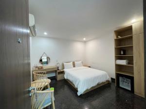 a bedroom with a bed and a desk and a mirror at Tuyet Suong Villa Hotel in Quảng Ngãi