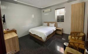a small bedroom with a bed and a window at Tuyet Suong Villa Hotel in Quảng Ngãi