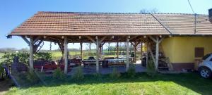 a large wooden pavilion with cars parked in a field at Tanya 360° in Lajosmizse +19 photos