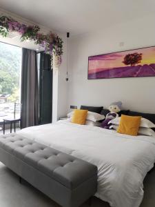 Un dormitorio con una gran cama blanca con almohadas amarillas. en Fantasy Homestay, en Yangshuo