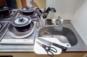 a kitchen sink with scissors and a cup in it at Zenith Garden TOGOSHI in Tokyo +116 photos