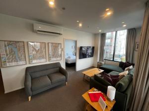 a living room with a couch and chairs and a table at Your Queenstown adventure base! in Queenstown