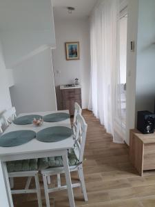 a dining room with a white table and chairs at Apartments Mersab in Živogošće