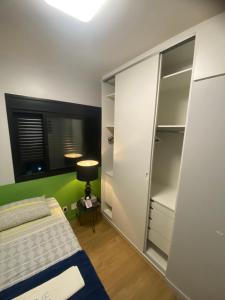 a bedroom with a bed and a closet at Quarto Individual Confortável em resort no Brás in Sao Paulo