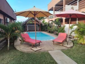 two chairs and an umbrella next to a pool at Couleur Café in Mandriankeniheny
