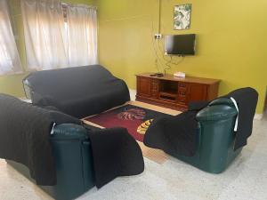 a living room with a couch and a chair at H&S RIS Homestay in Kuala Terengganu