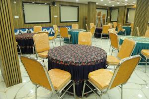 a room full of tables and chairs with blue table cloth at Akshayaa Grand in Visakhapatnam