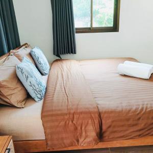 Una cama con dos almohadas encima en una habitación. en First Light beach bungalow 2, en Ko Pha Ngan
